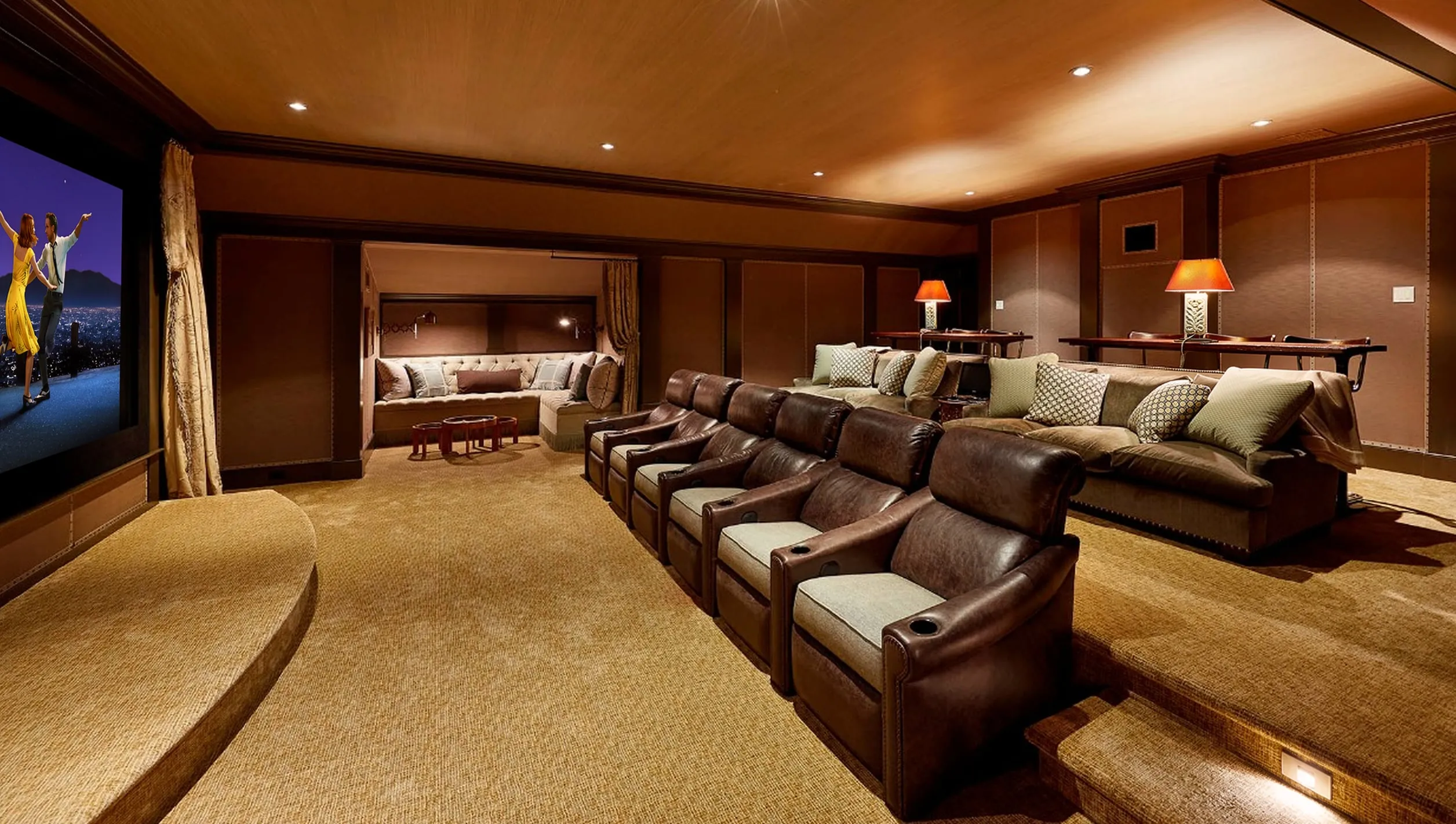 Home theater with a row of leather recliners, a lounge sofa, and a projection screen