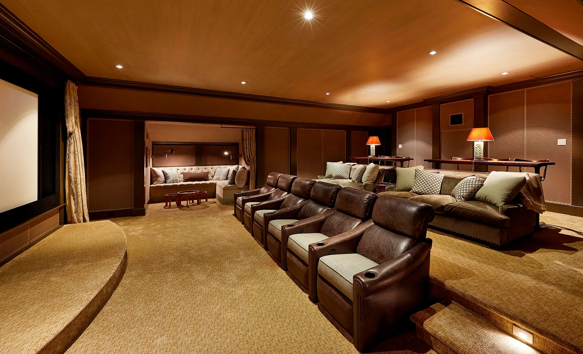 Home theater with a row of leather recliners, a lounge sofa, and a projection screen
